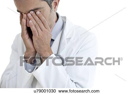 Male doctor rubbing eyes View Large Photo Image Stock Image - Male doctor rubbing eyes. Fotosearch