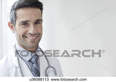 Male doctor smiling towards camera View Large Photo Image Stock Image - Male doctor smiling towards camera. Fotosearch