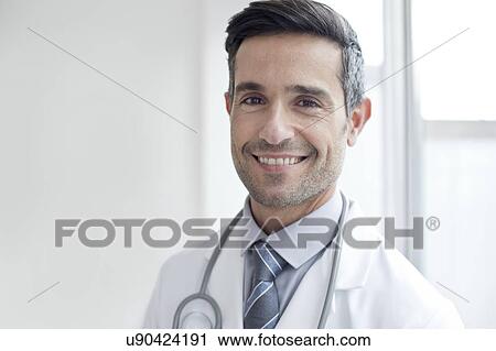 Male doctor smiling towards camera View Large Photo Image Stock Image - Male doctor smiling towards camera. Fotosearch