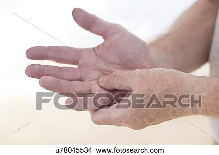 Picture - Man rubbing sore hand. Fotosearch