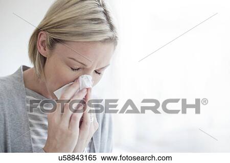 Mid adult woman blowing her nose View Large Photo Image Stock Photography - Mid adult woman blowing her nose. Fotosearch