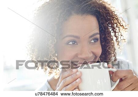 Picture - Mid adult woman drinking coffee. Fotosearch
