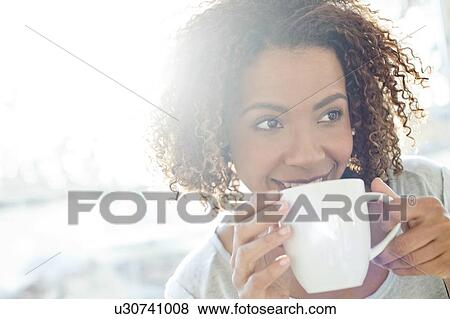 Stock Photo - Mid adult woman drinking coffee. Fotosearch