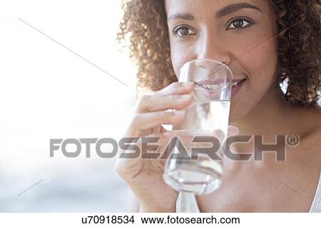 Picture - Mid adult woman drinking water. Fotosearch