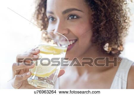 Picture - Mid adult woman drinking water. Fotosearch