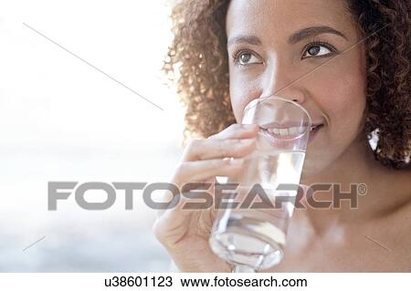 Mid adult woman drinking water View Large Photo Image Stock Image - Mid adult woman drinking water. Fotosearch