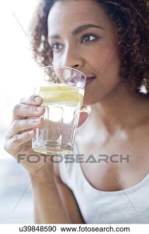 Mid adult woman drinking water View Large Photo Image Stock Image - Mid adult woman drinking water. Fotosearch