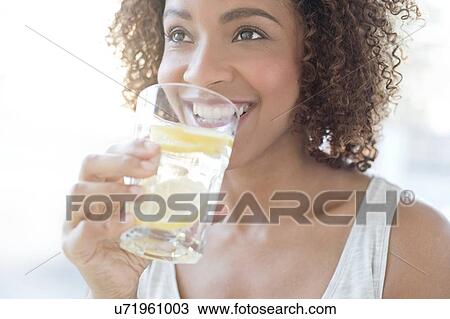 Mid adult woman drinking water View Large Photo Image Stock Image - Mid adult woman drinking water. Fotosearch