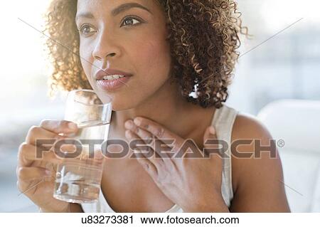 Stock Image - Mid adult woman drinking water. Fotosearch