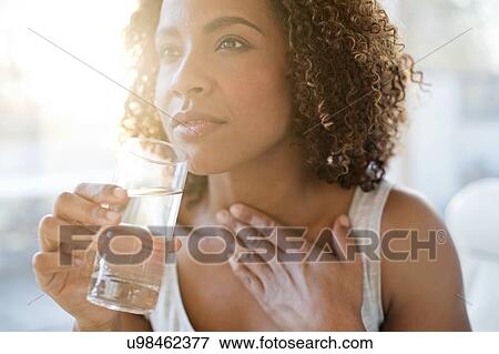 Mid adult woman drinking water View Large Photo Image Stock Photo - Mid adult woman drinking water. Fotosearch