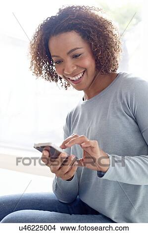 Mid adult woman using phone View Large Photo Image Picture - Mid adult woman using phone. Fotosearch