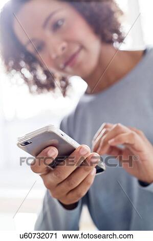 Stock Image - Mid adult woman using phone. Fotosearch