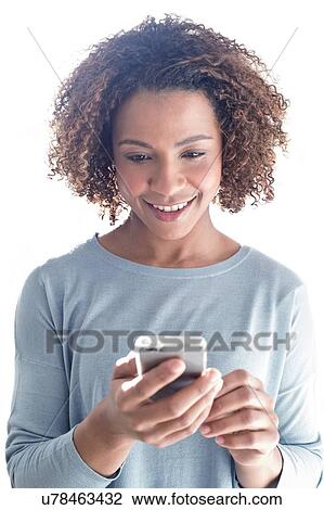 Stock Image - Mid adult woman using phone. Fotosearch