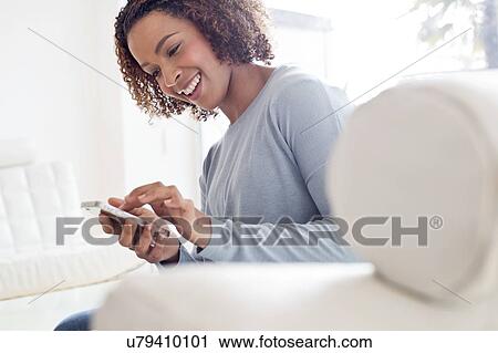 Stock Image - Mid adult woman using phone. Fotosearch