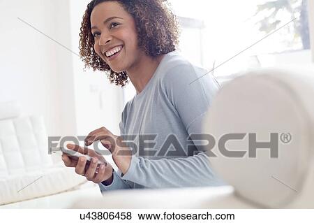 Mid adult woman using phone View Large Photo Image Stock Photo - Mid adult woman using phone. Fotosearch