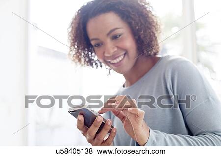 Mid adult woman using phone View Large Photo Image Stock Photo - Mid adult woman using phone. Fotosearch