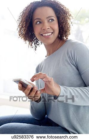 Mid adult woman using phone View Large Photo Image Stock Photograph - Mid adult woman using phone. Fotosearch