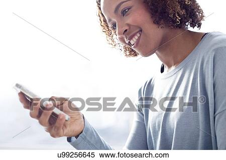 Stock Photography - Mid adult woman using phone. Fotosearch