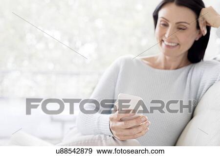 Mid adult woman using smartphone View Large Photo Image Stock Photo - Mid adult woman using smartphone. Fotosearch