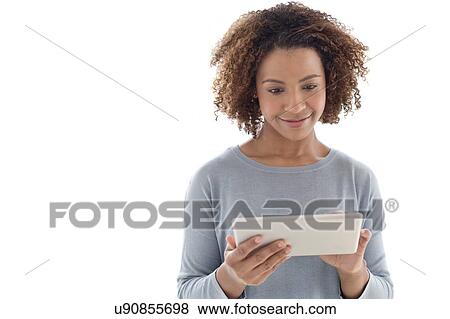Stock Photo - Mid adult woman using tablet. Fotosearch