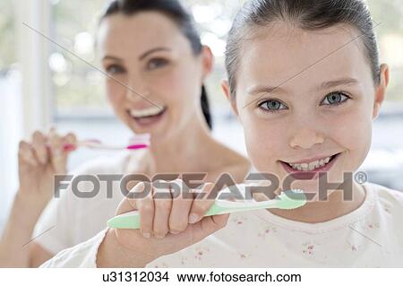 Mother and daughter brushing teeth View Large Photo Image Picture - Mother and daughter brushing teeth. Fotosearch