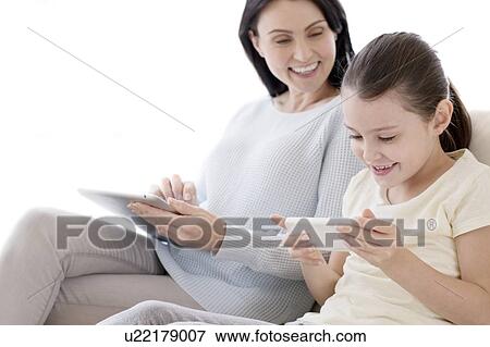 Mother and daughter with tablet and phone View Large Photo Image Stock Photo - Mother and daughter with tablet and phone. Fotosearch