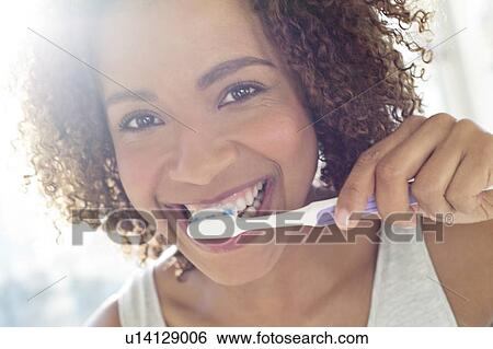 Portrait of woman brushing teeth View Large Photo Image Stock Photograph - Portrait of woman brushing teeth. Fotosearch