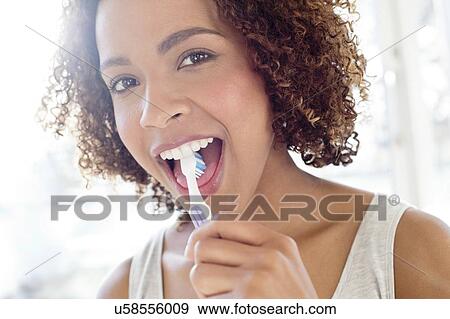 Stock Photo - Portrait of woman brushing tongue. Fotosearch