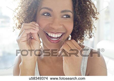 Portrait of woman flossing teeth View Large Photo Image Picture - Portrait of woman flossing teeth. Fotosearch