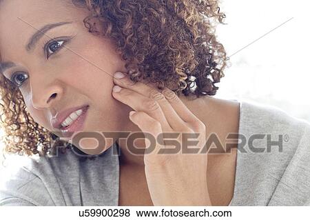 Stock Photo - Portrait of woman touching face. Fotosearch