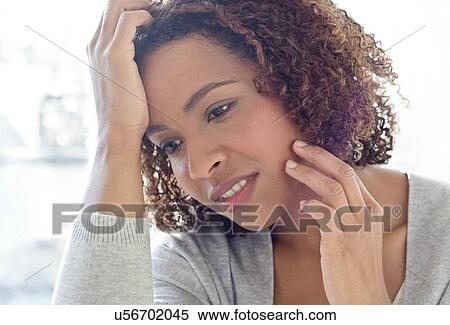 Stock Photography - Portrait of woman touching face. Fotosearch