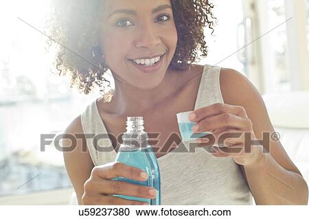 Portrait of woman using mouthwash View Large Photo Image Stock Image - Portrait of woman using mouthwash. Fotosearch