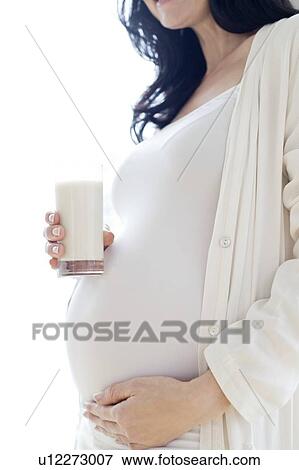 Pregnant woman touching tummy with milk View Large Photo Image Stock Photo - Pregnant woman touching tummy with milk. Fotosearch