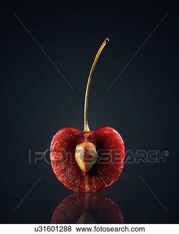 Stock Photo - Red cherry in half against black background. Fotosearch