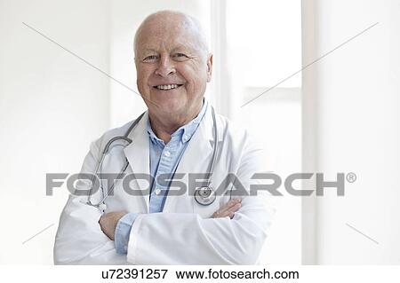 Senior male doctor smiling towards camera View Large Photo Image Stock Photo - Senior male doctor smiling towards camera. Fotosearch