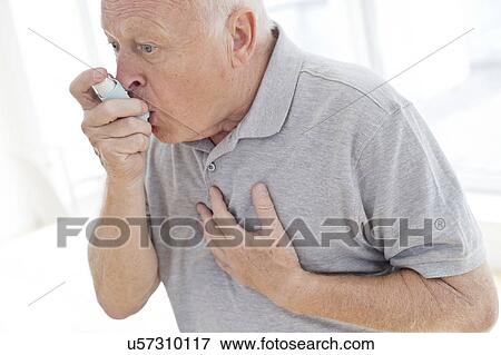 Stock Photo - Senior man using inhaler, holding chest. Fotosearch