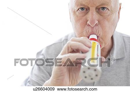Stock Photo - Senior man using peak flow metre. Fotosearch