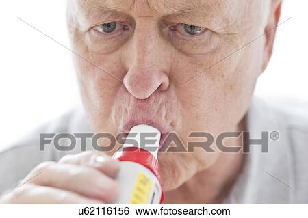 Stock Photograph - Senior man using peak flow metre. Fotosearch