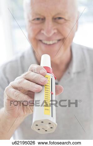 Senior man using peak flow metre View Large Photo Image Stock Photograph - Senior man using peak flow metre. Fotosearch