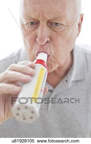 Stock Photography - Senior man using peak flow metre. Fotosearch