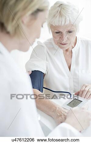 Stock Photograph - Senior woman having blood pressure taken. Fotosearch