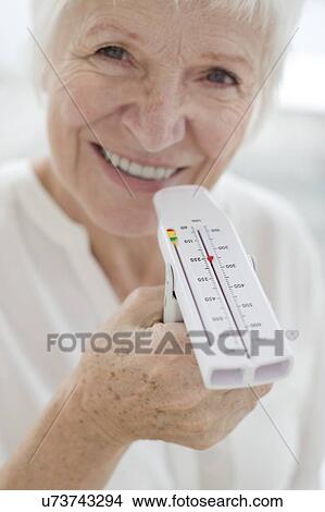 Senior woman holding peak flow metre View Large Photo Image Picture - Senior woman holding peak flow metre. Fotosearch