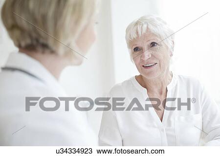 Senior woman listening to female doctor View Large Photo Image Stock Image - Senior woman listening to female doctor. Fotosearch