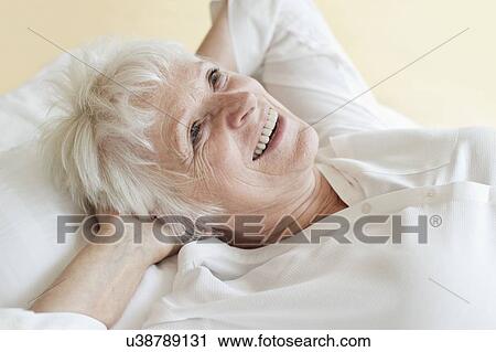 Stock Image - Senior woman lying down. Fotosearch