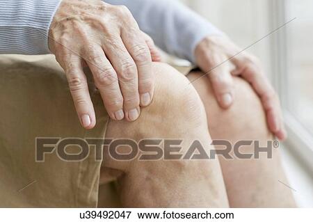 Stock Photo - Senior woman touching knees. Fotosearch