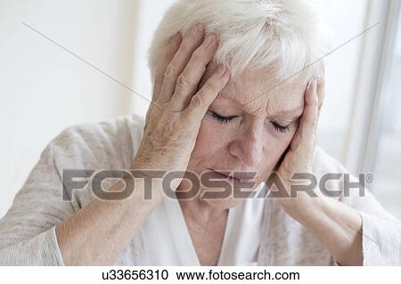 Stock Image - Senior woman with headache. Fotosearch