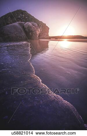Sunset at water's edge on beach View Large Photo Image Picture - Sunset at water's edge on beach. Fotosearch