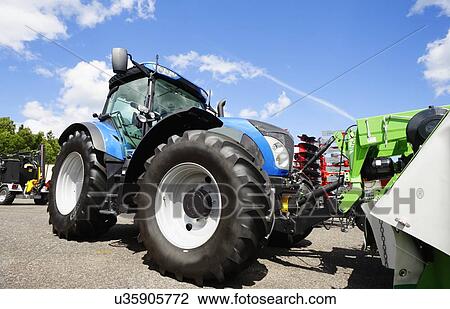 Stock Image - Tractor coupled with mower. Fotosearch