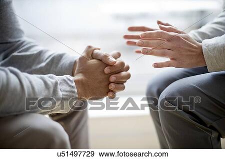 Stock Photo - Two people sitting face to face. Fotosearch