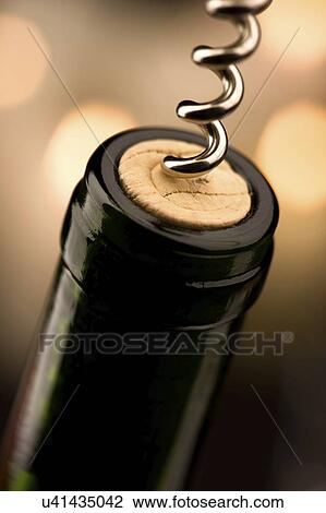 Stock Image - Wine bottle with corkscrew removing cork. Fotosearch
